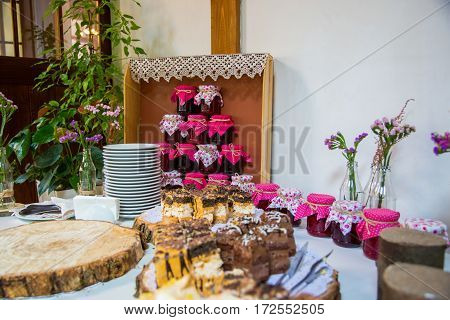 Jars of jam are on the buffet table in the shape of a pyramid