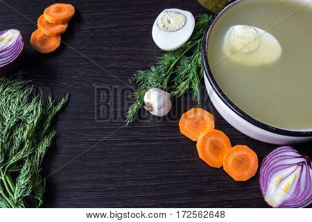 Soup with sorrel vegetables and boiled egg red onion carrots garlic dill on dark wooden table