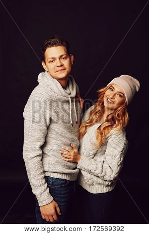 Cheerful couple in winter clothes hugging and kissing. Process with VSCO S3 preset