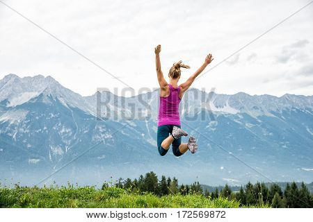Young woman without backpack jumping in the mountains. Alps. Austria. Insbruk