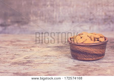 Almond. Almonds in a bowl on the old wooden background.
