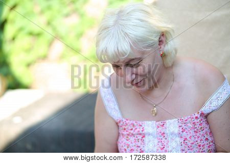 an elderly woman in the garden outdoors in dress