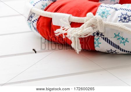 Lifebuoy handmade pillow on white wooden table with copyspace