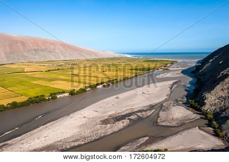 Valley of Ocona River as it flows into the Pacific ocean in the Arequipa Region. Lots of agriculture in the dry landscape in the river valley. Peru