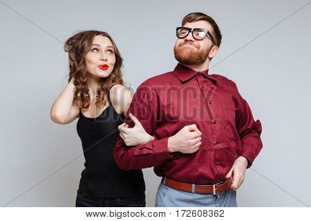 Pretty Woman which holding hand of Funny Bearded Male nerd in eyeglasses and funny clothes