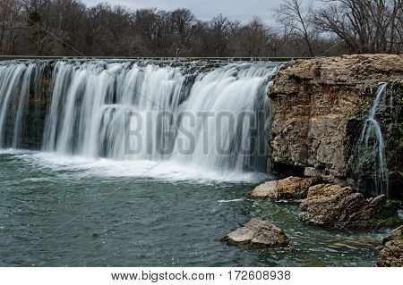Waterfall among boulders on a warm winter day makes a scenic view