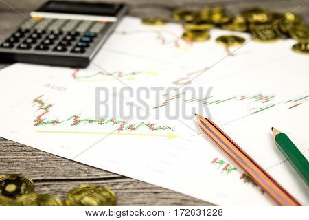 calculator, pencils and coins on graffica the Dow Jones on forex market at grey table