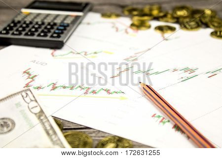 calculator, pencils, banknote and coins on graffica the Dow Jones on forex market at grey table