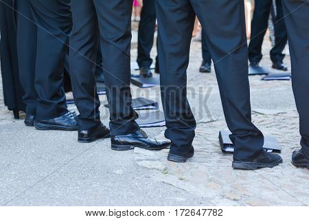 Man's feet in black trousers and black shoes