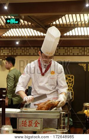 BEIJING - FEBRUARY 22: Cutting peking duck on a plate in the original Quanjude restaurant at the Qianmen street in Beijing, China, February 22, 2016.