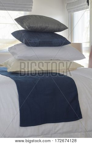 Stacking Pillows On Bed With Wall And Window In Background