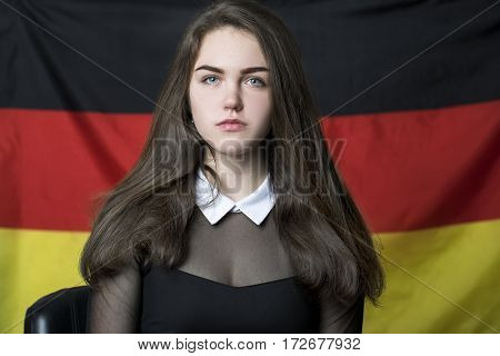 Portrait of a beautiful calm brunette girl in the background of the German flag