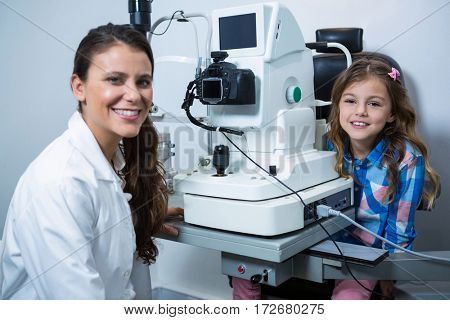 Female optometrist with young patient in ophthalmology clinic