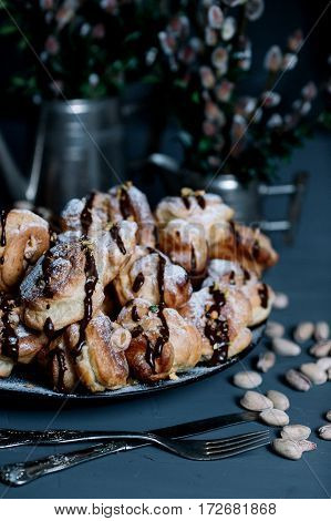 Still life with profiteroles and bouquets of pussy willow on dark background
