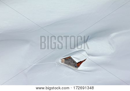 Romantic hut covered by snow in the alps seen from above