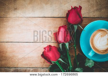 Red rose and cup of coffee on wooden background with copy space.Valentines Day background concept Wedding day.Top view vintage tone