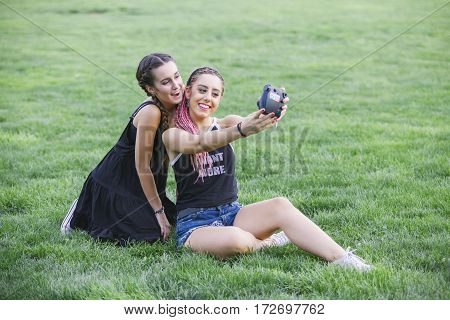 teen women taking a photo to theirselves isolated on the park