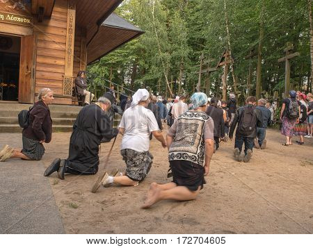 Grabarka Poland - August 14 2016: Pilgrims of the Orthodox Church moving on knees around the church on the Holy Mount of Grabarka.