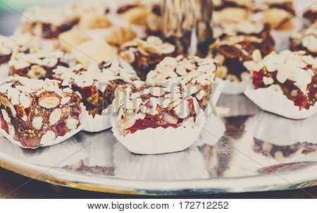 Caramel cakes on tray on banquet table. Pastry, biscuits, cookies and chocolate candies closeup