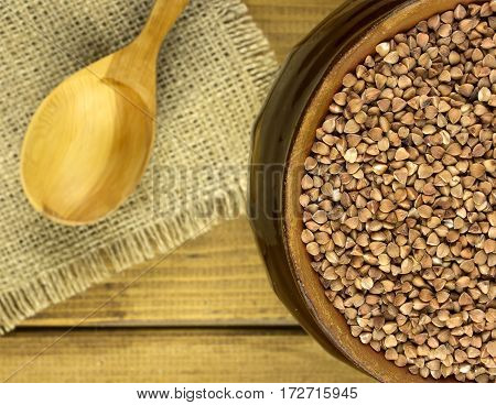 Buckwheat groats in a bowl and wooden scoop