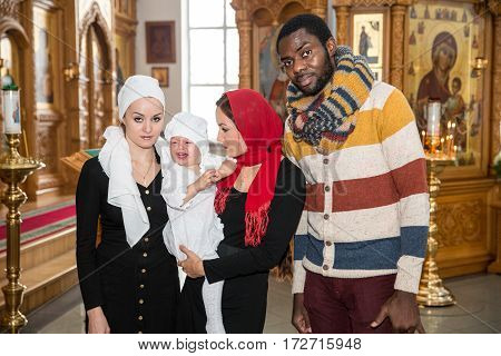 ALMATY KAZAKHSTAN - DECEMBER 17: Christening ceremony on December 17 2013 in Almaty Kazakhstan. Family celebrating baptism in Orthodox Church - Monastery of St. Matrona