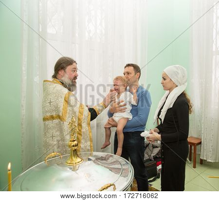 ALMATY KAZAKHSTAN - DECEMBER 17: Christening ceremony on December 17 2013 in Almaty Kazakhstan. Family celebrating baptism in Orthodox Church - Monastery of St. Matrona