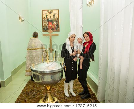 ALMATY KAZAKHSTAN - DECEMBER 17: Christening ceremony on December 17 2013 in Almaty Kazakhstan. Family celebrating baptism in Orthodox Church - Monastery of St. Matrona