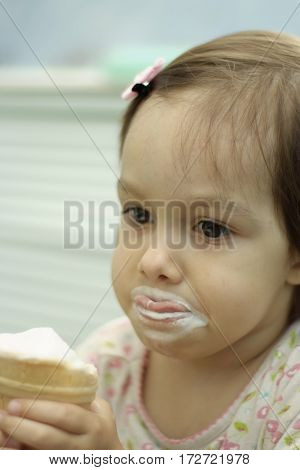 Portrait of a little cute girl eating ice cream