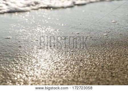 The sand of the beach washed by the waves of the sea