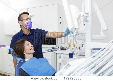 Dentist Explaining Xray On Screen To Female Patient