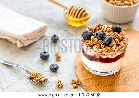 Healthy fitness breakfast from yoghurt with muesli and blue berries on kitchen table background