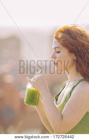 healthy lifestyle of young woman drinking a green vitamins apple juice with a strow.