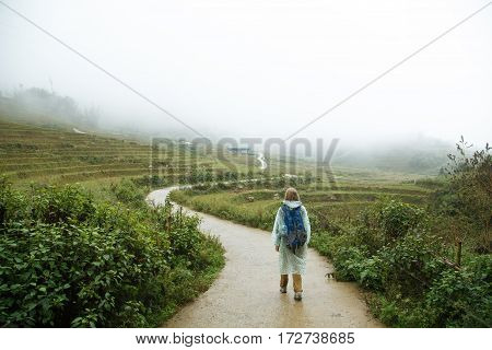 Backpacker traveling on the road across rice field in Sapa