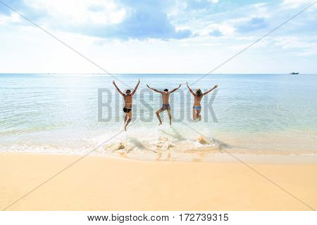 Young group of people jumping in sea
