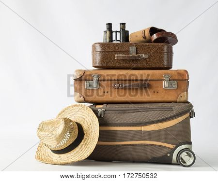 Vintage and modern suitcases binoculars and hat. Concept of travel.