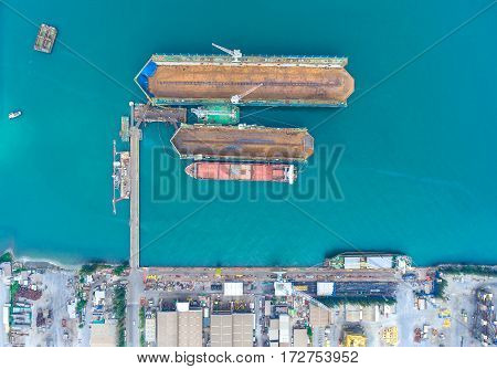 container ship in import export and business logistic.By crane Trade Port Shipping.Tugboat assisting cargo to harbor.Aerial view.