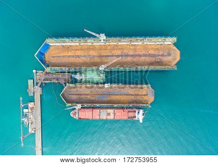 container ship in import export and business logistic.By crane Trade Port Shipping.Tugboat assisting cargo to harbor.Aerial view.