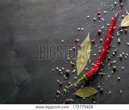 Red Pepper Pungent Spices And Bay Leaf On The Black Tree. View From Above.