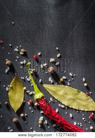 Red Pepper Pungent Spices And Bay Leaf On The Black Tree. View From Above.