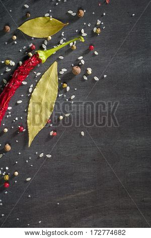 Red Pepper Pungent Spices And Bay Leaf On The Black Tree. View From Above.