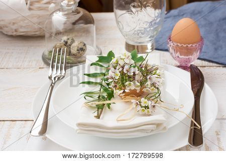 Easter decoration table setting white plates napkin white flowers in eggshell quail eggs green leaves basket outdoors kinfolk