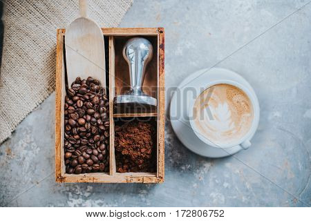 Coffee beans tamper and a cup of delicious coffee