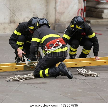 Firemen During Rescue Operations With A Wooden Ladder