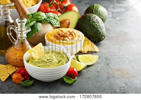 Guakamole and hummus dips with vegetables copy space