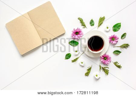 Froral flat lay with cup of coffee and craft notepaper on white background top view mockup