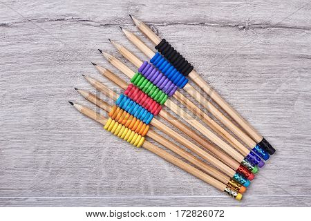 Graphite pencils on wooden background. Erasers on graphite pencils. Happy to be an artist.