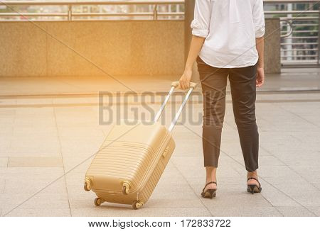 Businesswoman traveler with luggage at city background