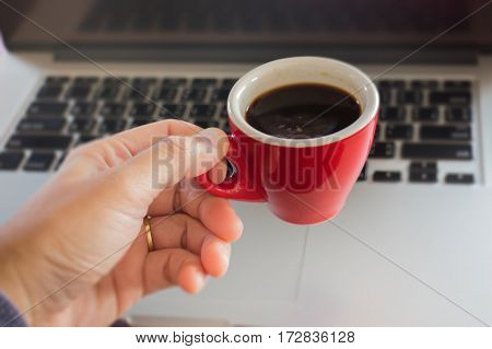 Hand on red cup of espresso stock photo