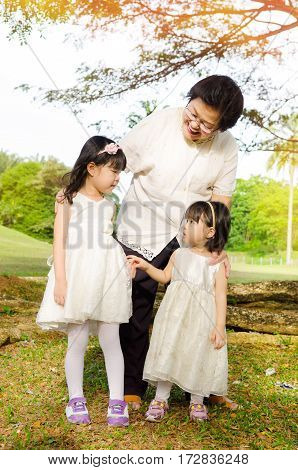 Outodoor portrait of Asian senior woman together with grandchildren