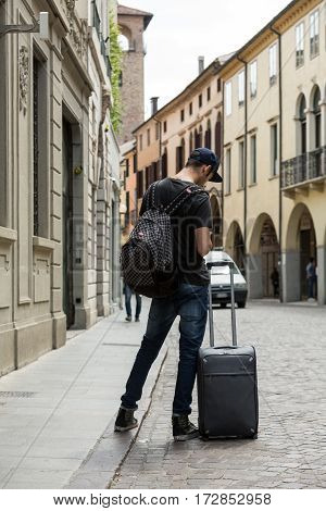 PADUA  ITALY - MAY 3 2016: the lost tourist with the suitcase on the street in Padua. Italy